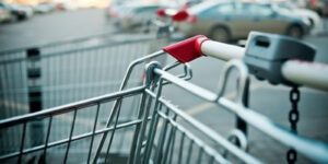 Image of shopping cart in a parking lot full of cars