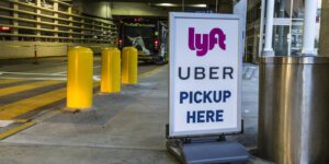 Lyft and Uber sign outside of an airport at pickup area