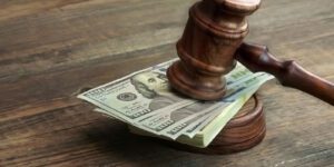 Image of a stack of 100 dollar bills under a gavel