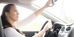 Image of woman adjusting her rearview mirror