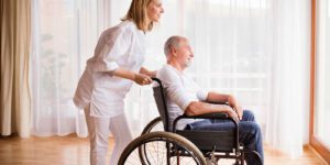 Image of woman pushing an elderly man in a wheel chair