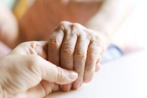 Image of elderly person holding hands with someone