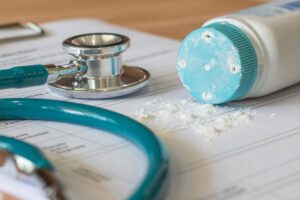 Image of stethoscope, paperwork, and talc powder spilling on table