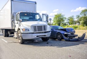 Image of box truck and small car in a collision