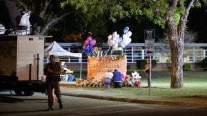 Image of memorial set up at Robb Elementary School sign