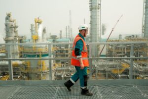 Image of man in safety gear walking at a chemical plant