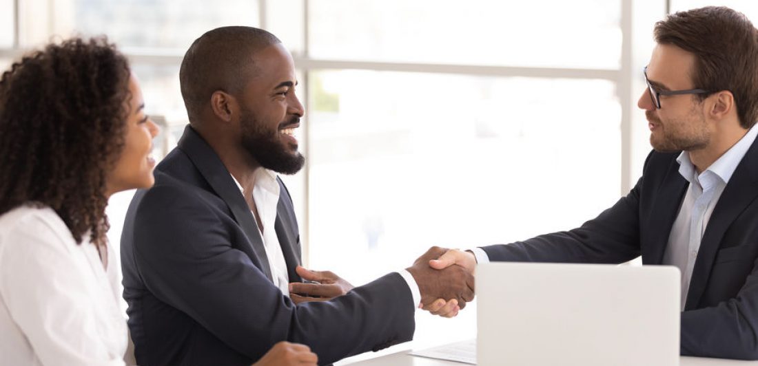 Three people in a meeting shaking hands