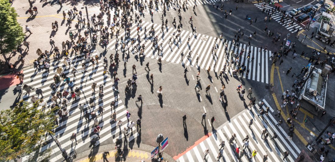 Image of a large crosswalk in a metropolitan city with a large number of pedestrians