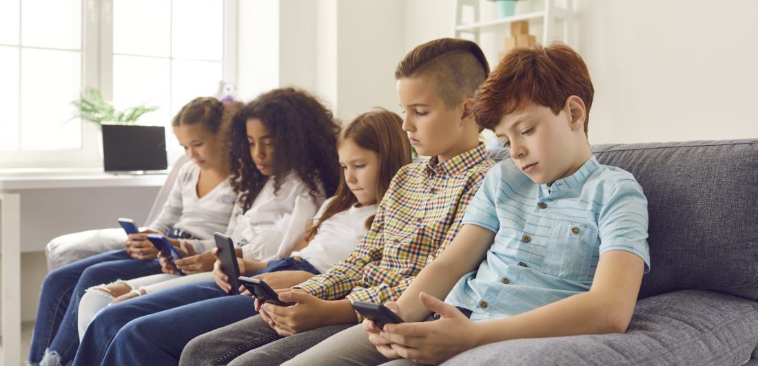 Image of children looking at their cell phones