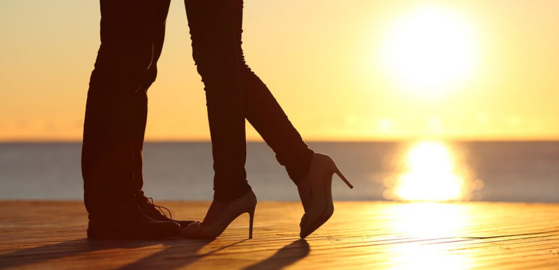 Image of silhouette of couple's legs at sunset