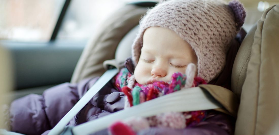 Image of sleeping toddler in winter coat in car seat