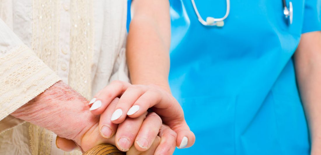 Image of healthcare worker comforting an elderly person holding a cane