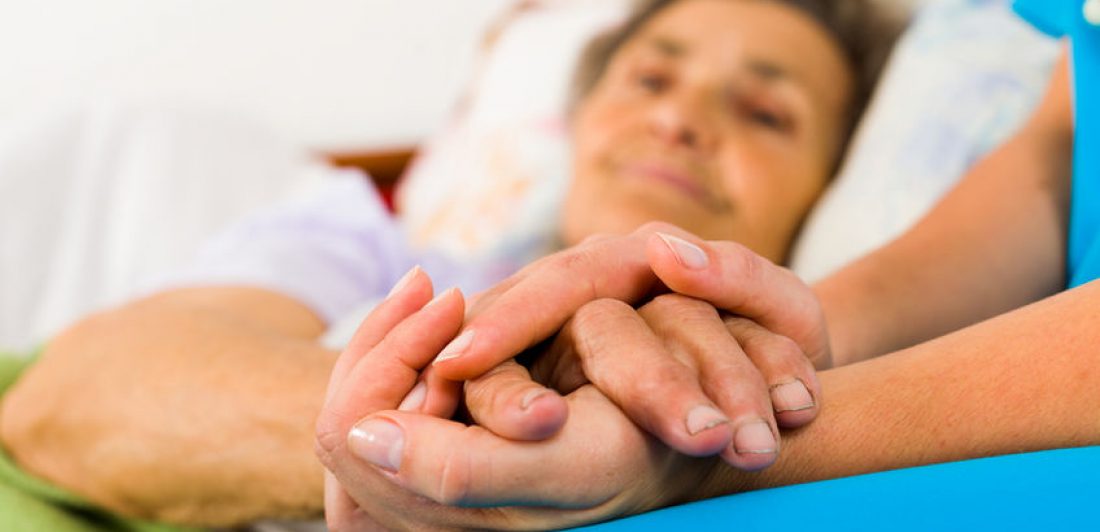 Image of medical professional holding an elderly person's hand