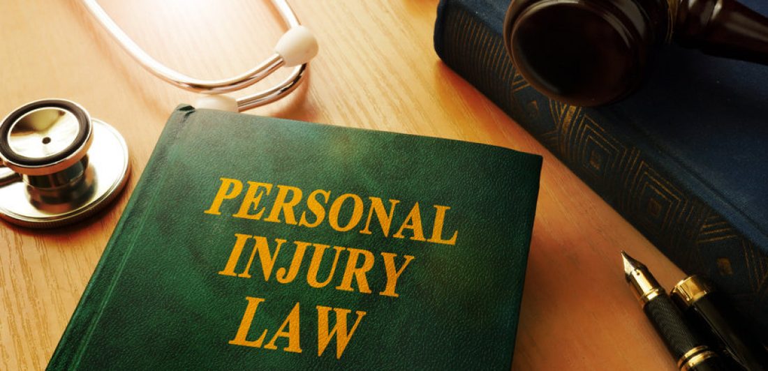 Image of a Personal Injury Law book on a table with a gavel, pen, and stethoscope