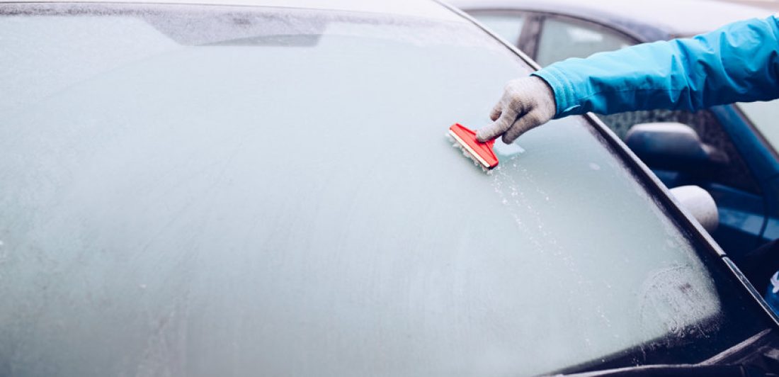 Image of person scraping ice off of a vehicle window