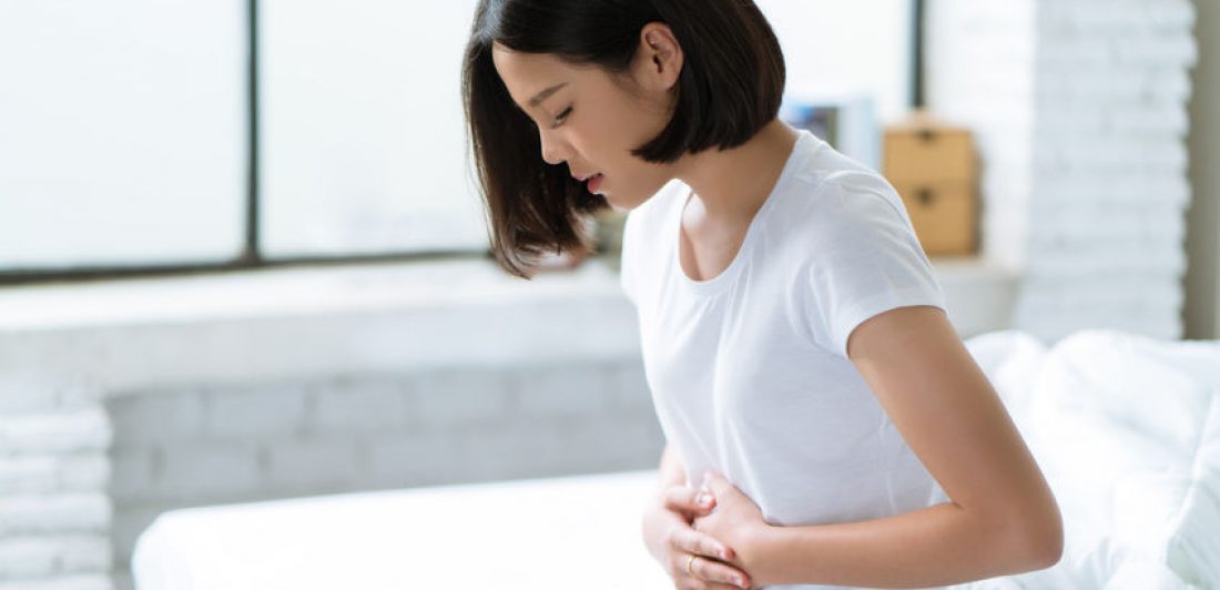 Image of woman holding her stomach to indicate abdominal pain