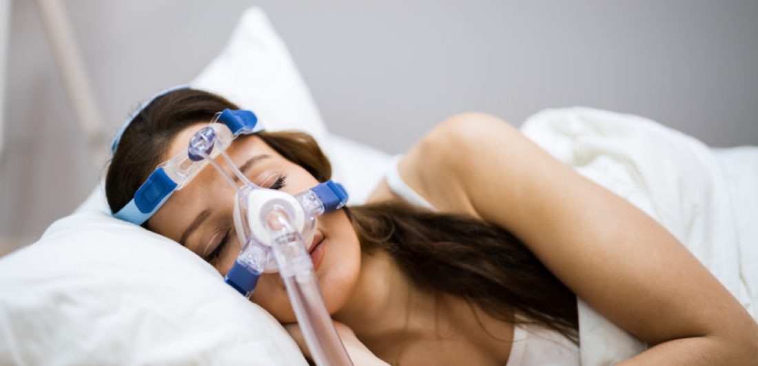 Image of woman wearing a CPAP mask while sleeping