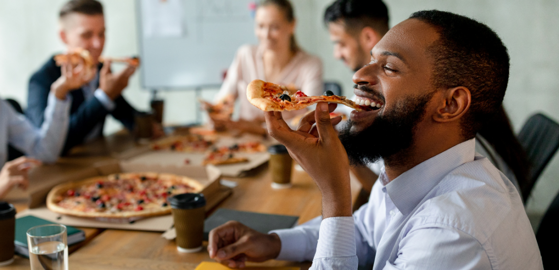 Image of happy people eating pizza at a table