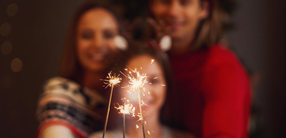 Image of happy couple with daughter holding sparklers