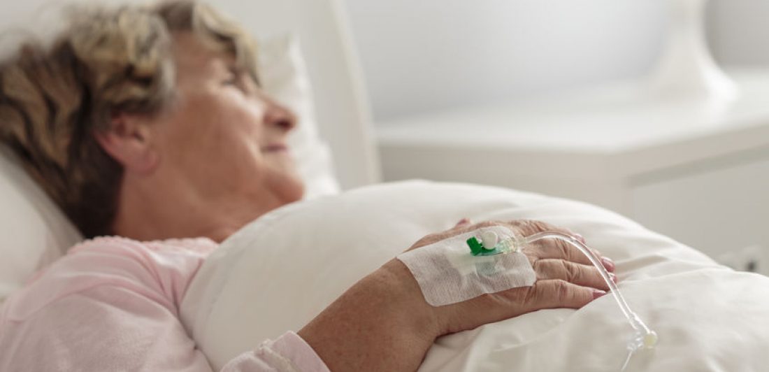 Image of elderly woman in a hospital bed with an IV