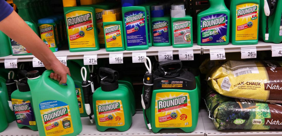 Image of person taking a container of Round Up off a store shelf