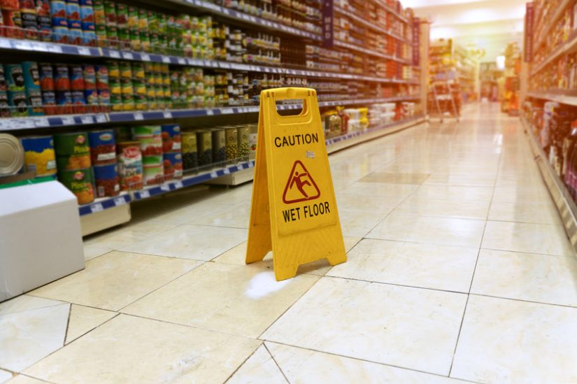 Image of grocery store isle with caution wet floor sign