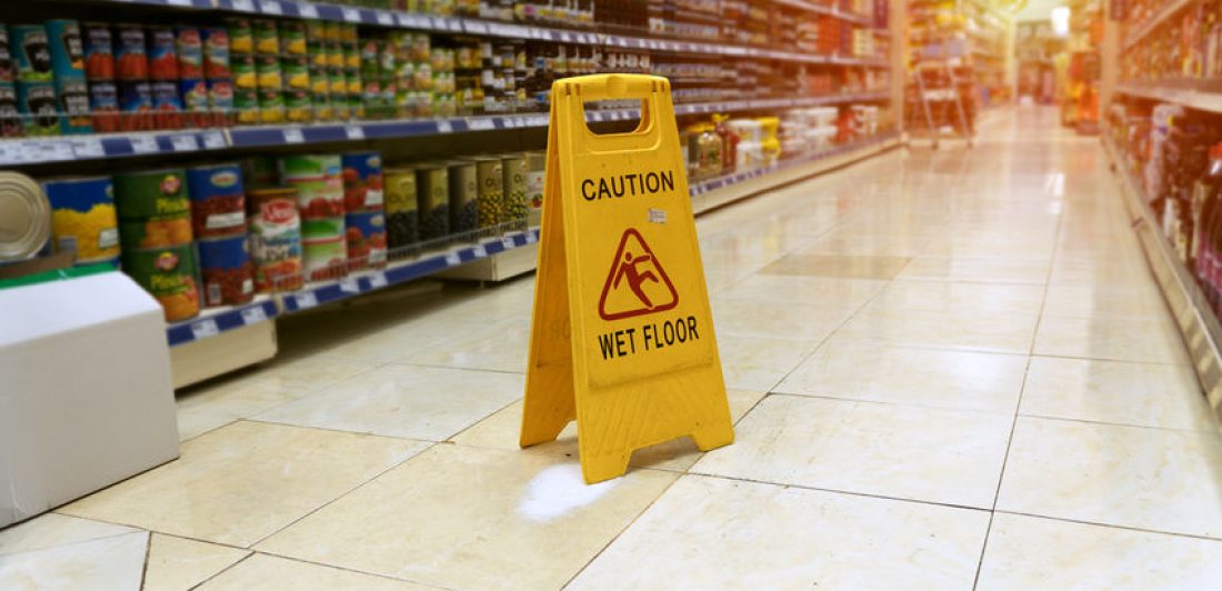 Image of grocery store isle with caution wet floor sign