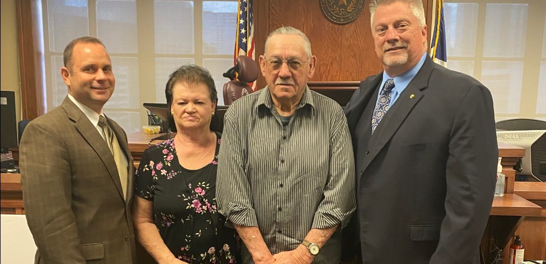 Image of three men and one woman following lawsuit being awarded