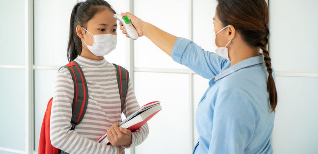 Image of student wearing a mask having her temperature taken