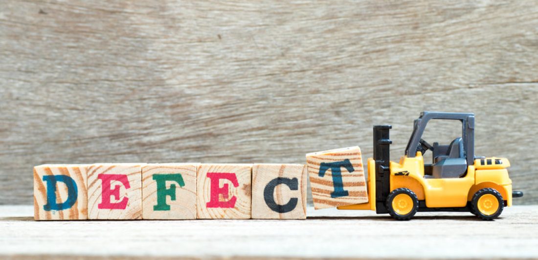 Image of toy fork lift with block letters spelling out DEFECT while the fork lift picks up the T block