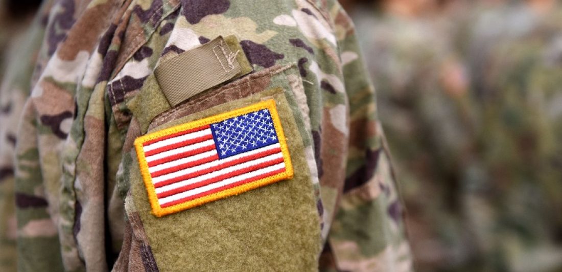 Image of military person in uniform with a flag patch on the sleeve