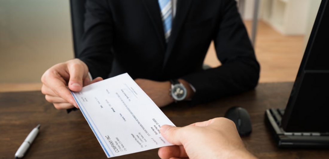 Image of two people exchanging a check