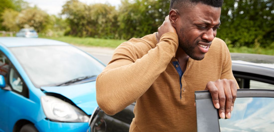 Image of man holding his neck in pain after a car accident