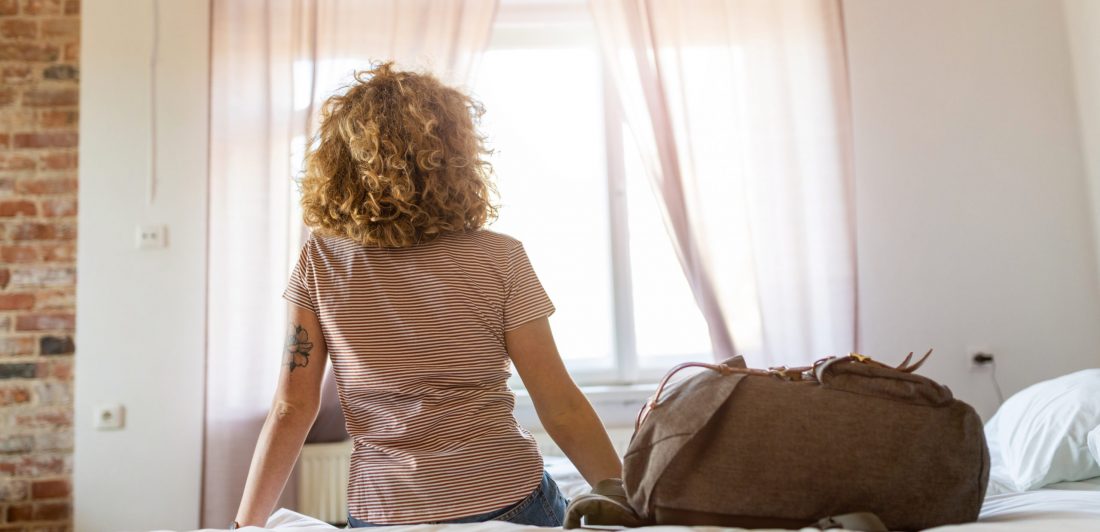 Image of woman on bed with bag packed