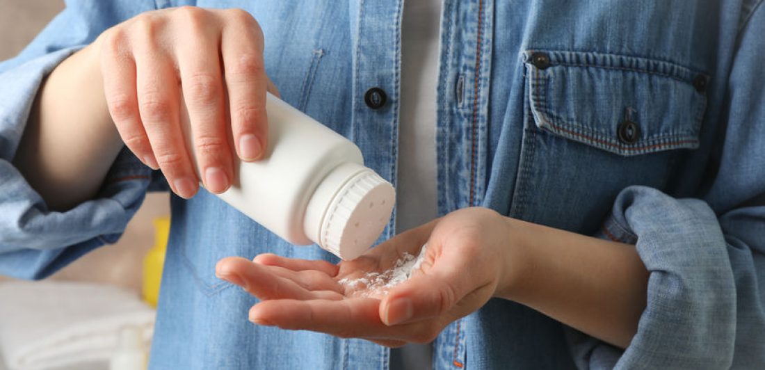 Person pouring talcum powder in their hand