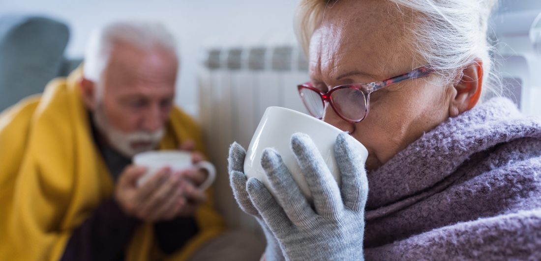 Image of two older people driving warm beverages from mugs