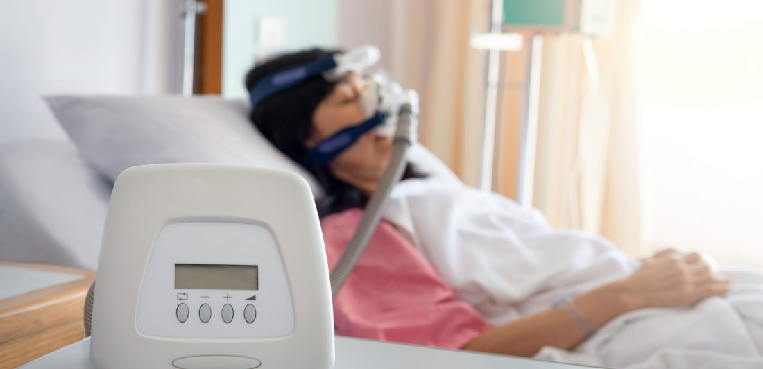 Image of a woman wearing a CPAP machine