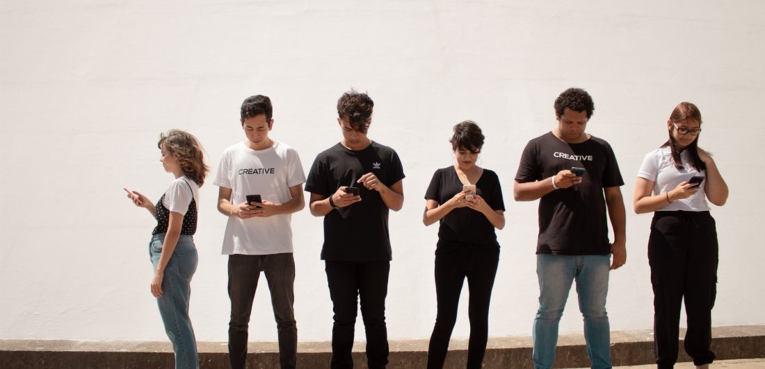 Image of people looking at their cell phones