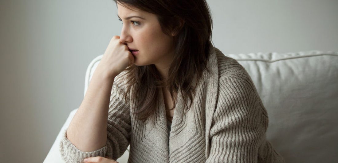 Woman looking thoughtful with her chin on her hand