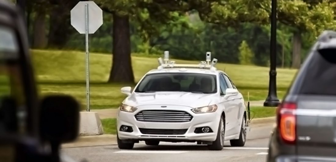 Image of white vehicle driving on the road with various other vehicles