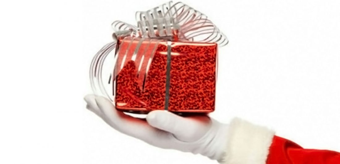 Image of Santa Claus hand holding a red gift with a silver bow