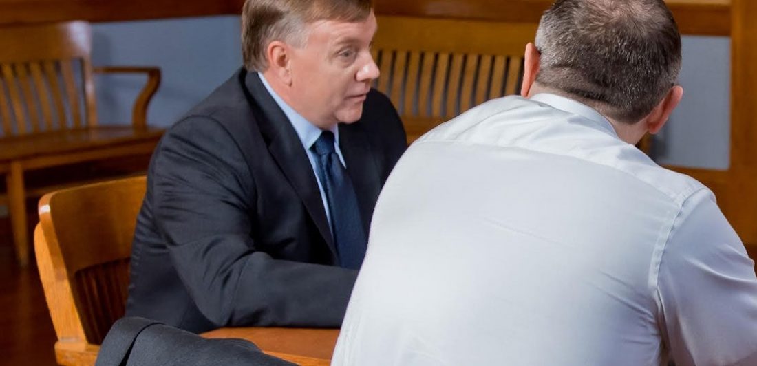 Image of Craig Carlson talking to a man at a table