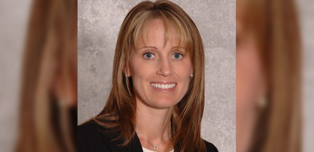 Image of woman with blonde hair and bands in a black suit with a white top