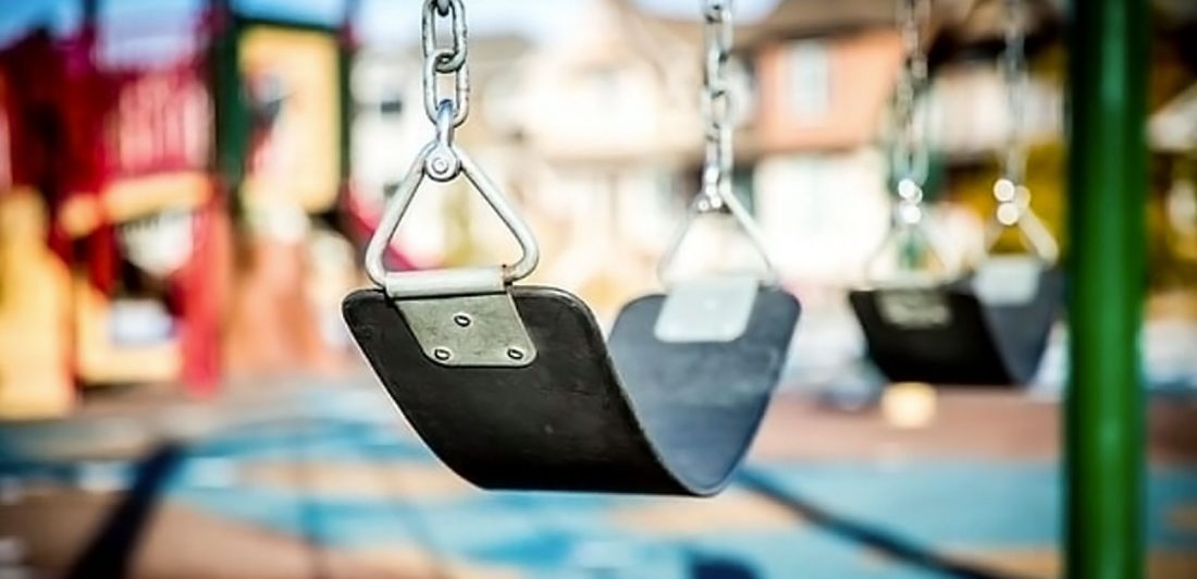 Image of empty swings on a playground