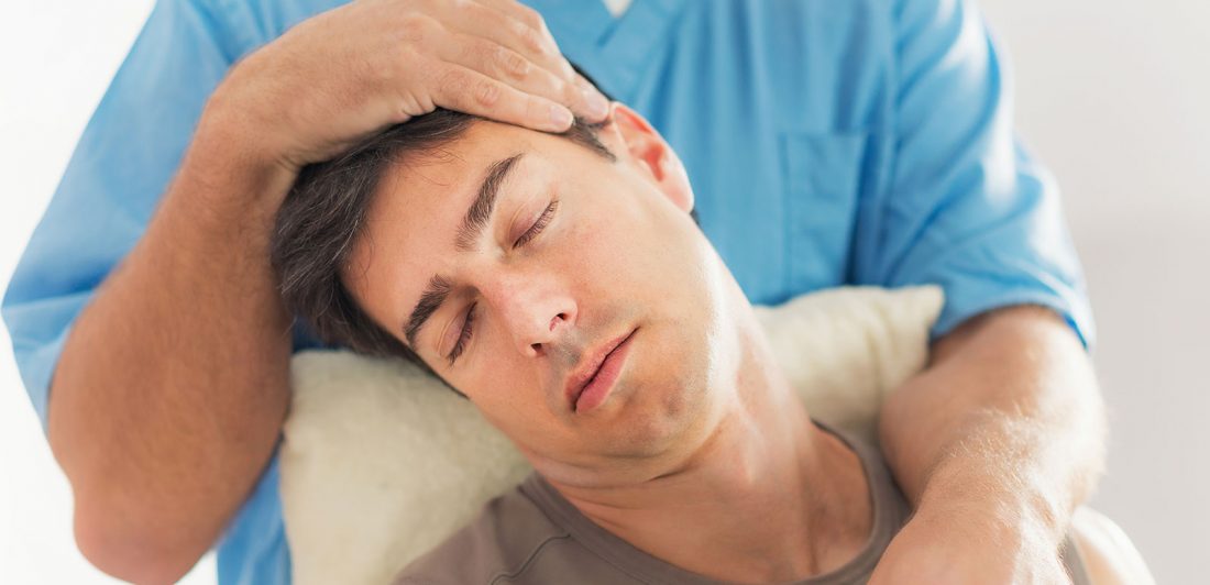 Image of chiropractor doing an adjustment on man's neck