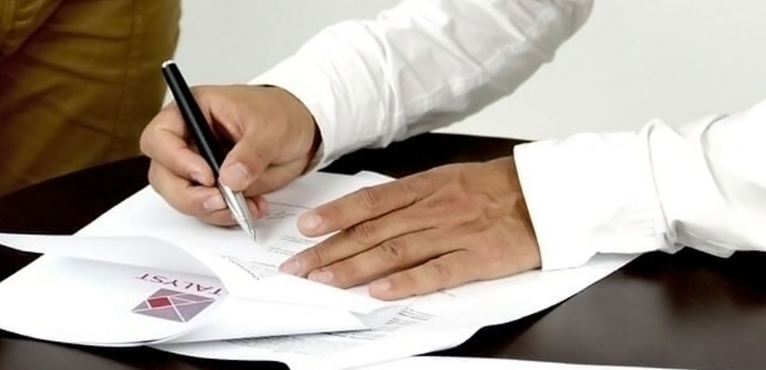 Image of a person signing paperwork