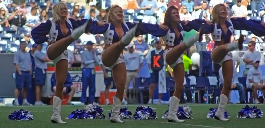 Image of Dallas Cowboys cheerleaders doing high kicks on the field