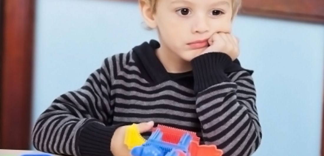 Image of a child looking sad with a toy in their hand