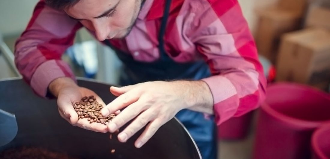 Image of man in an apron sorting coffee beans