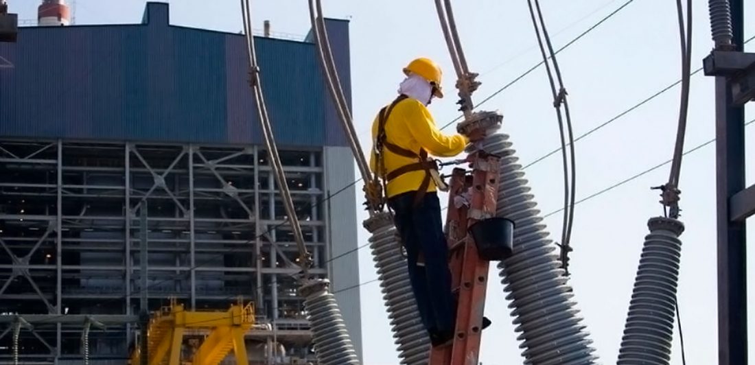 Image of worker in safety gear working on power lines